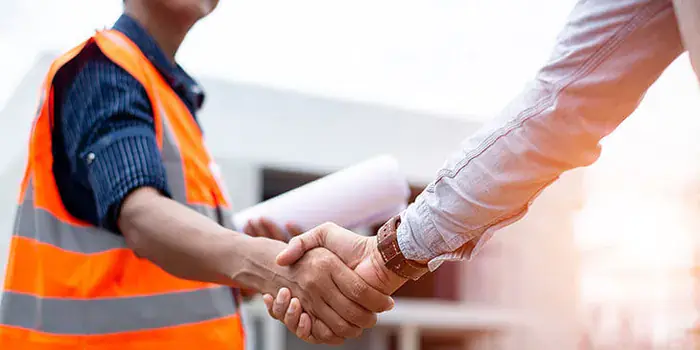 Poignée de main entre un ouvrier et un chef de chantier