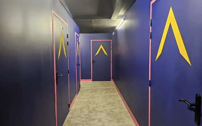 Couloir coloré desservant les salles d'un escape game