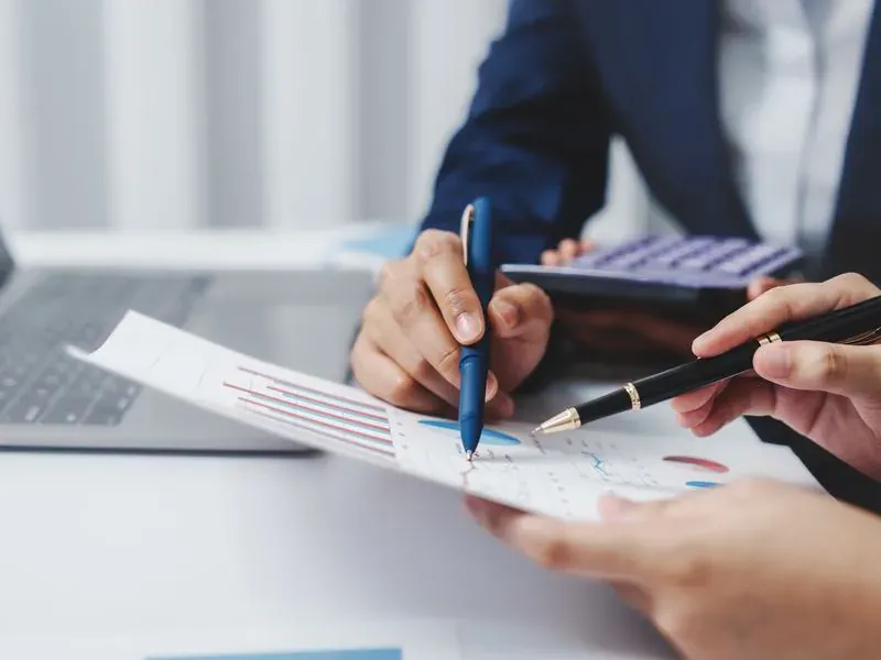 Deux personnes analysant des tableaux de résultats lors d'une formation